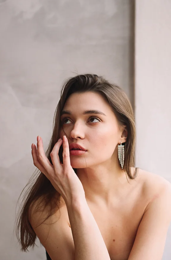 Brunette woman feeling her face