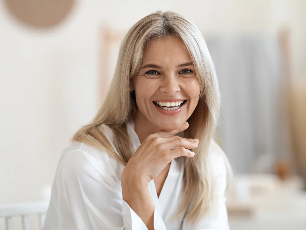 Woman smiling with her hand on her chin - Revive Medical Spa