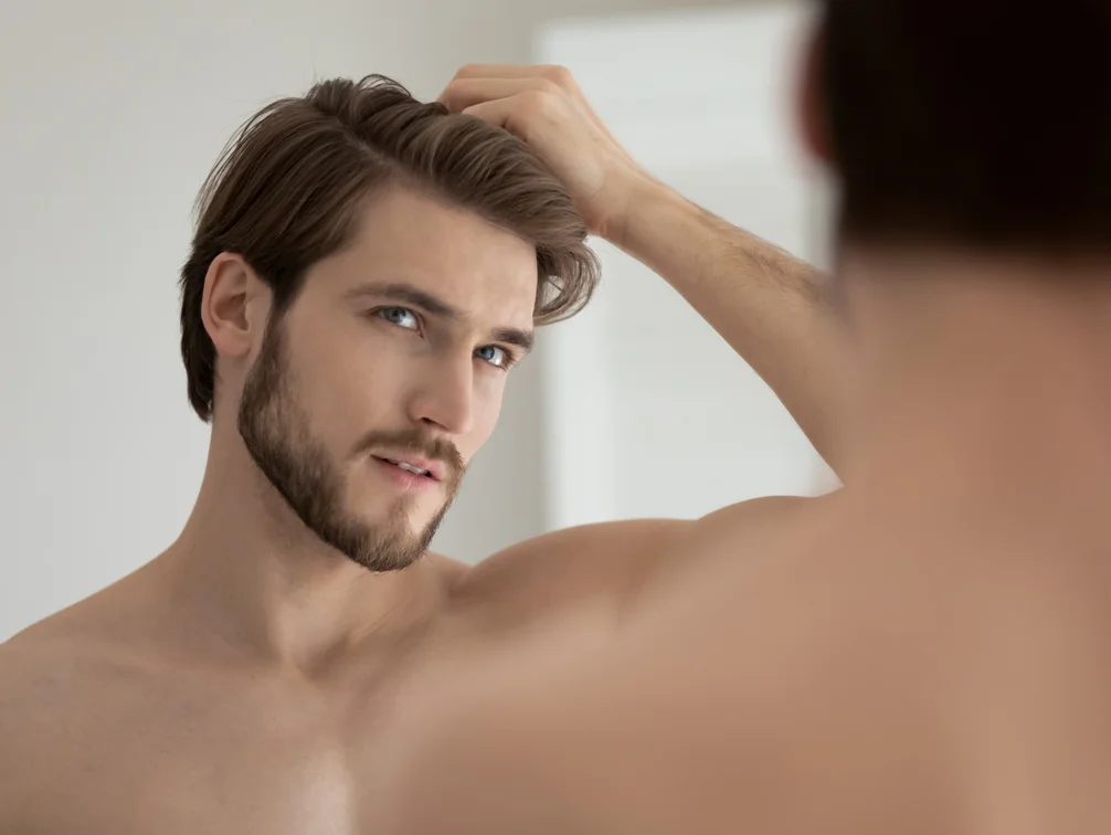 Male looking in the mirror - Hair Restoration