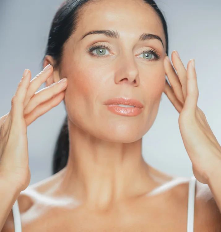 Woman feeling her upper cheeks